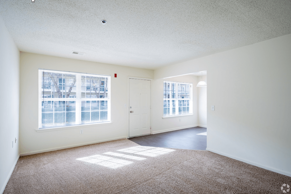 the living room and dining room of an empty apartment