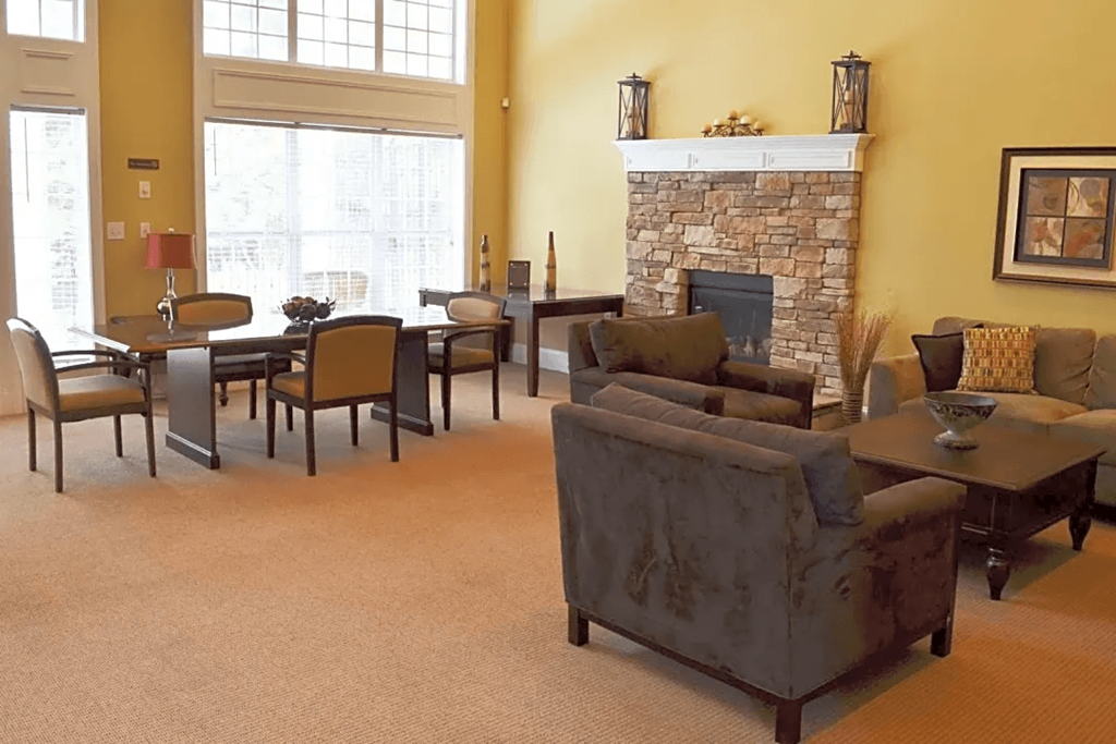 a living room with a fireplace and a table and chairs