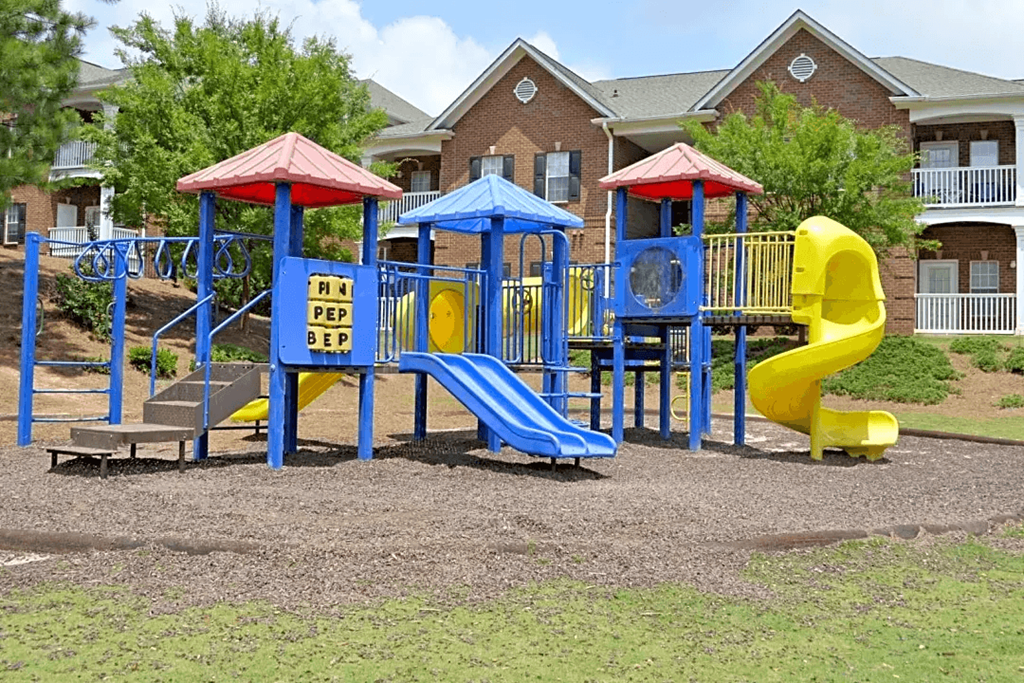 a playground with a blue and yellow swing set