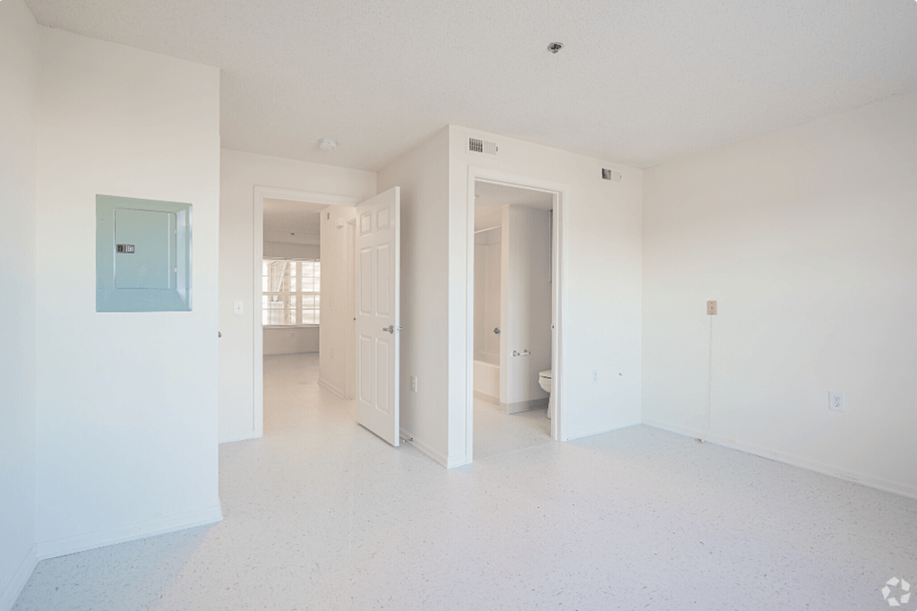an empty living room with white walls and a blue door