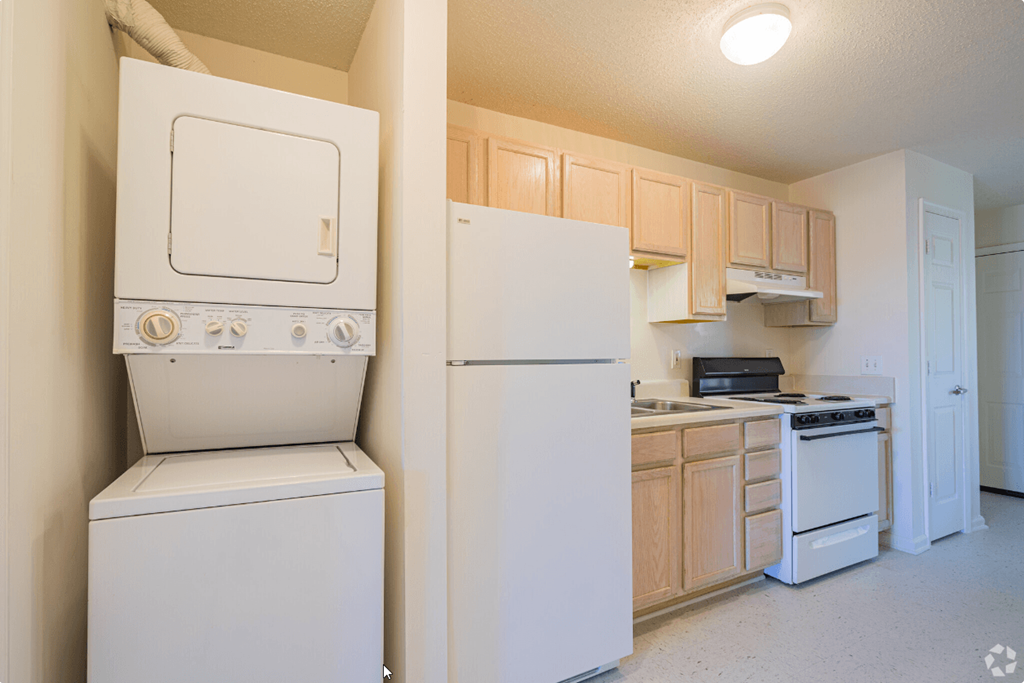 a kitchen with white appliances and wooden cabinets