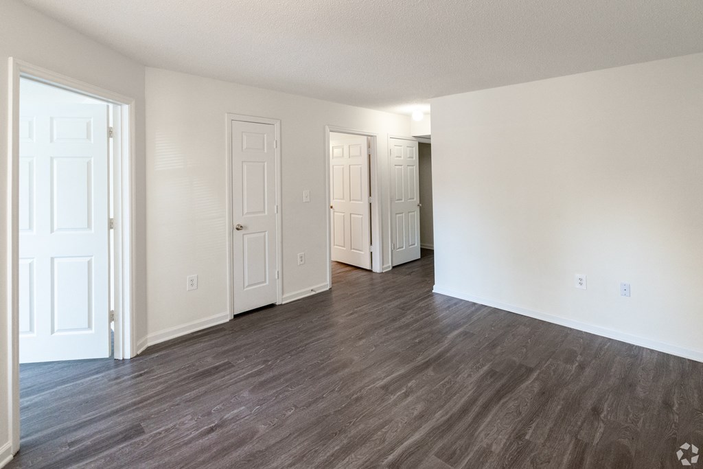 an empty living room with white walls and wood flooring at Pendleton Townhomes Apartments, North Carolina