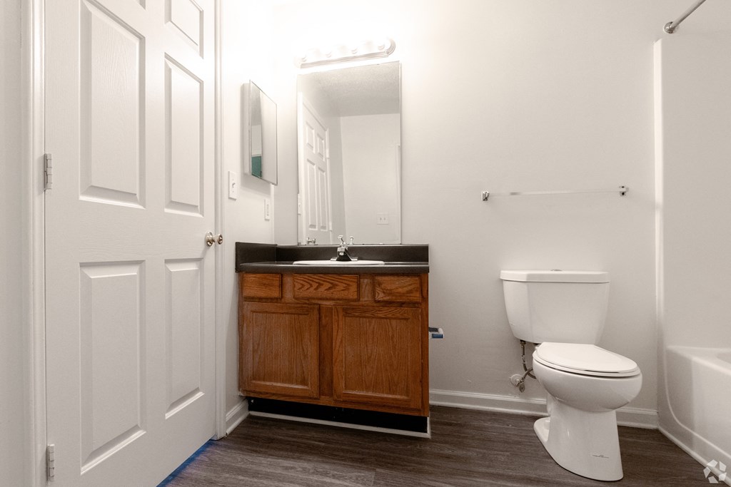 a bathroom with a toilet and a sink and a mirror at Pendleton Townhomes Apartments, Durham