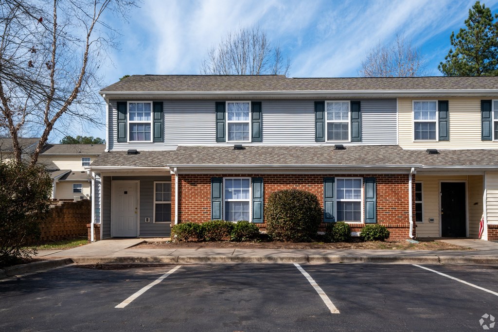 the front of an apartment building with a parking lot at Pendleton Townhomes Apartments, North Carolina