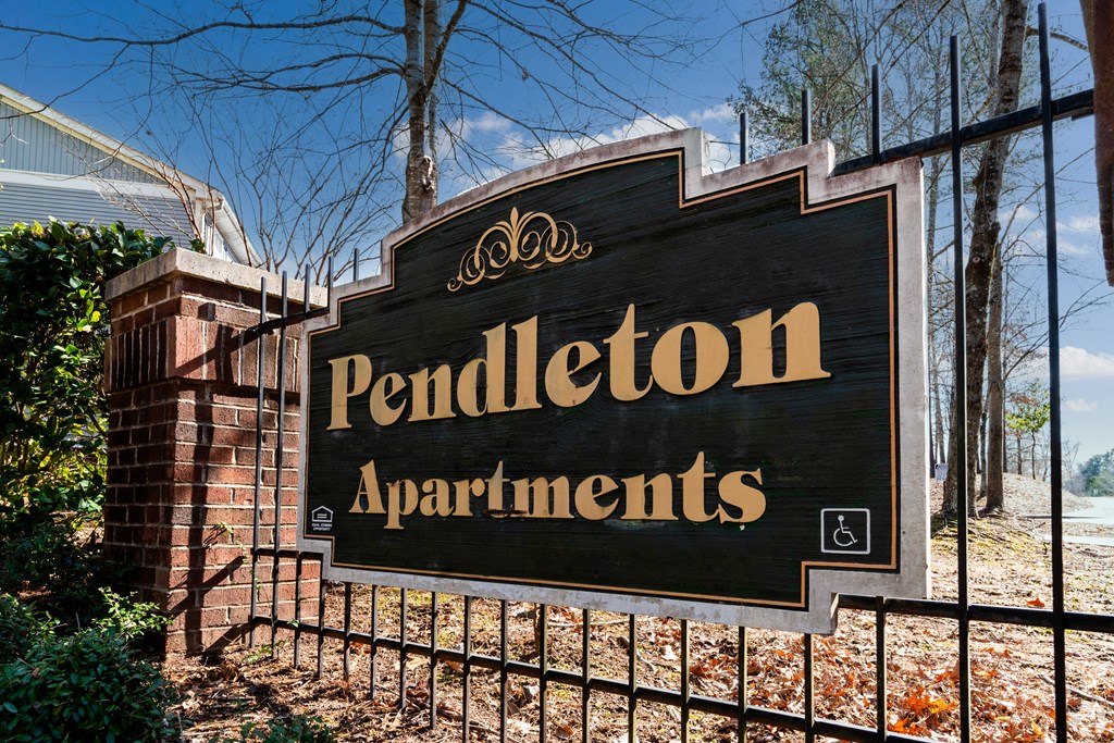 a sign in front of a fence at Pendleton Townhomes Apartments, Durham, North Carolina