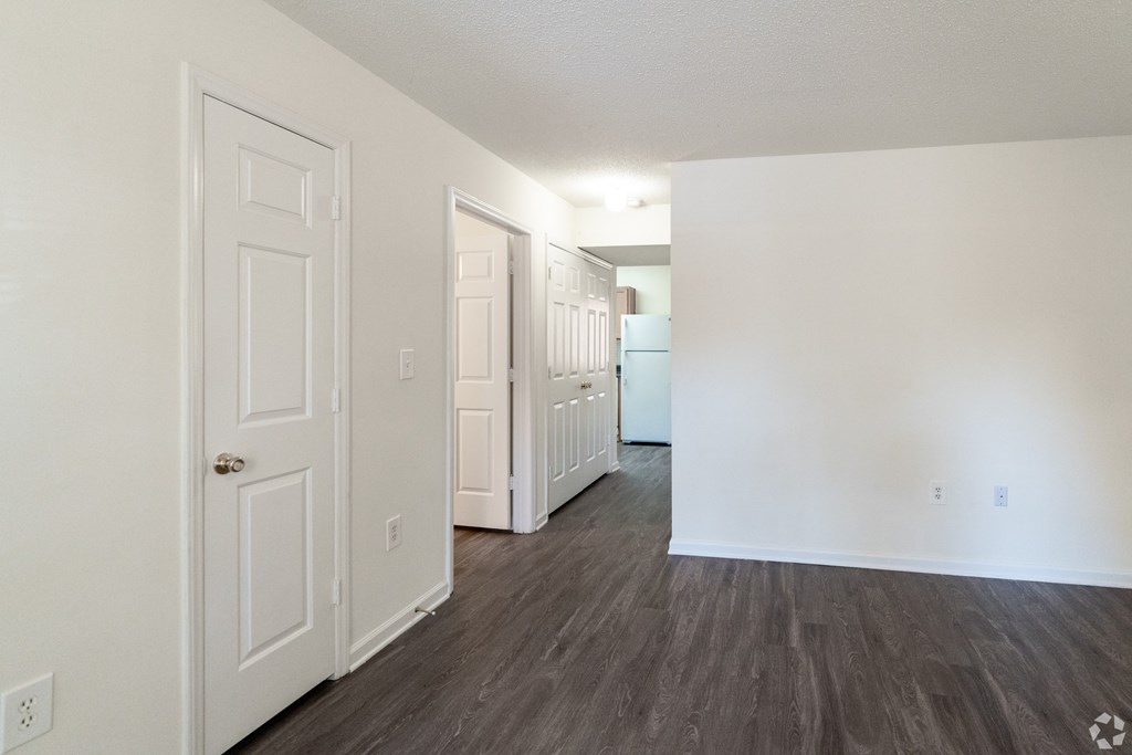 the living room of an apartment with white walls and wood flooring at Pendleton Townhomes Apartments, Durham, North Carolina