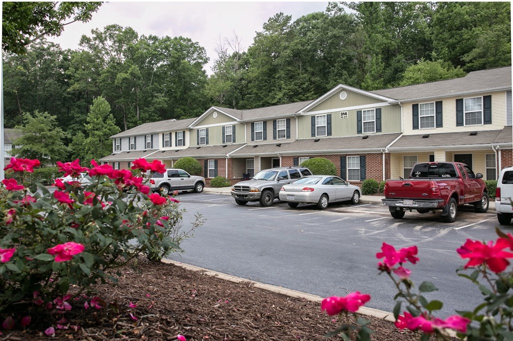 a parking lot in front of a building at Pendleton Townhomes Apartments, Durham, 27703