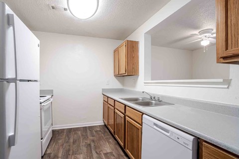 A kitchen with white appliances and wooden cabinets.