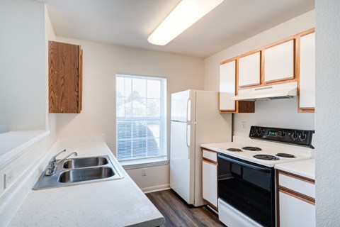 A kitchen with a black oven and white countertops.