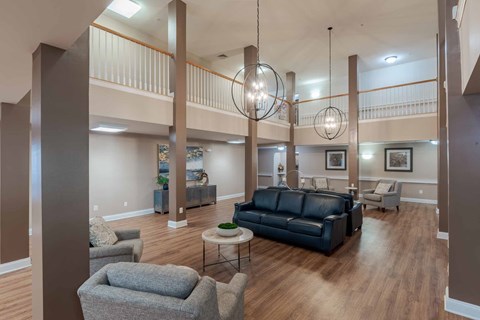A living room with a black couch and a grey armchair.