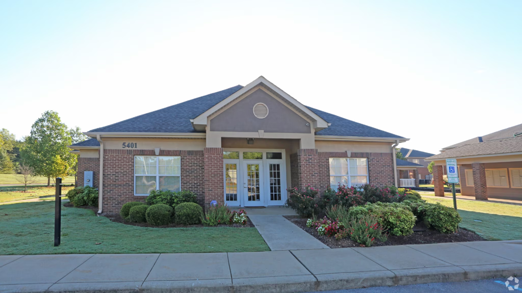 the front of a brick house with a sidewalk in front