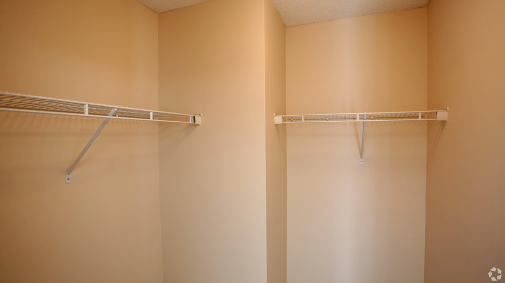 a empty closet in a bathroom with two empty shelves