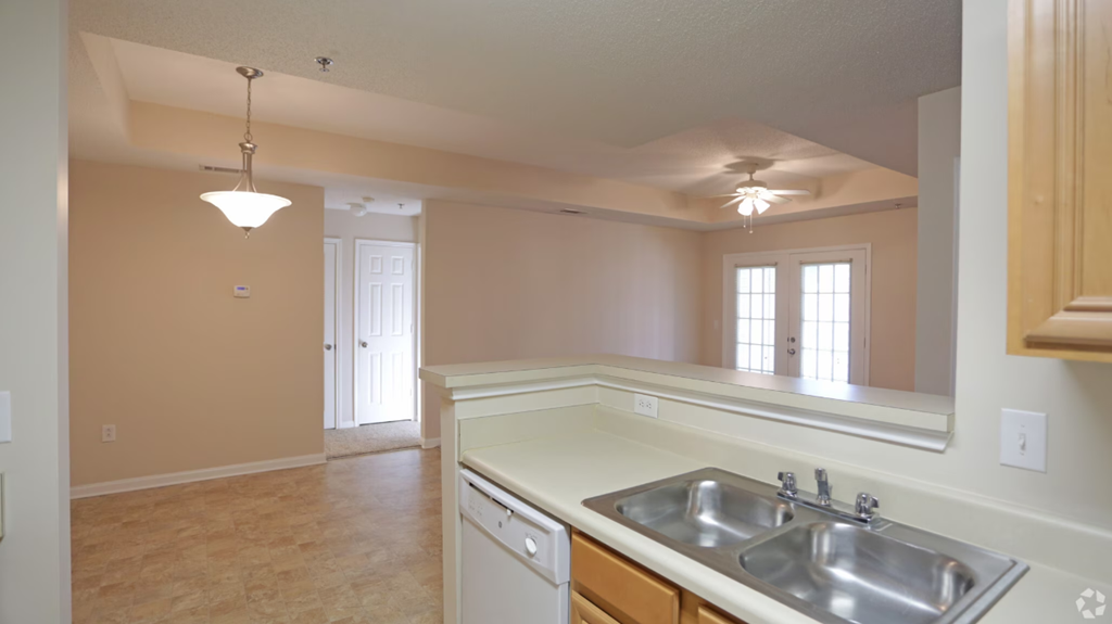 an empty kitchen with a sink and a counter top
