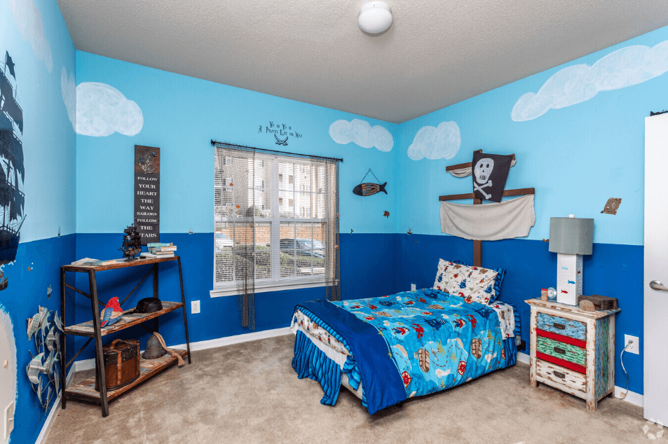 a bedroom with a bed and a window with clouds on the wall