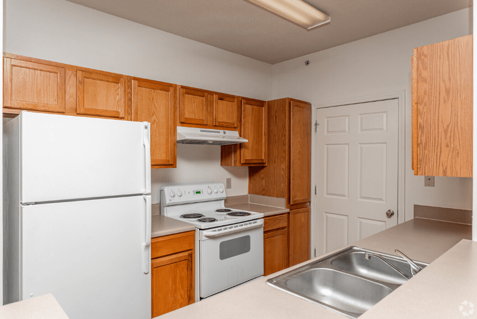 a kitchen with white appliances and wooden cabinets