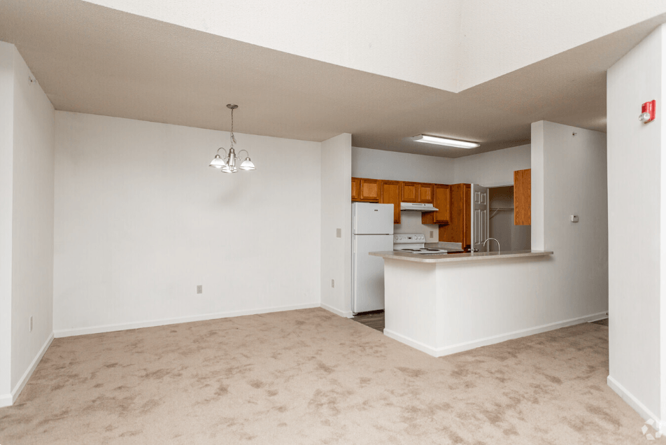 an empty living room and kitchen with white walls and flooring