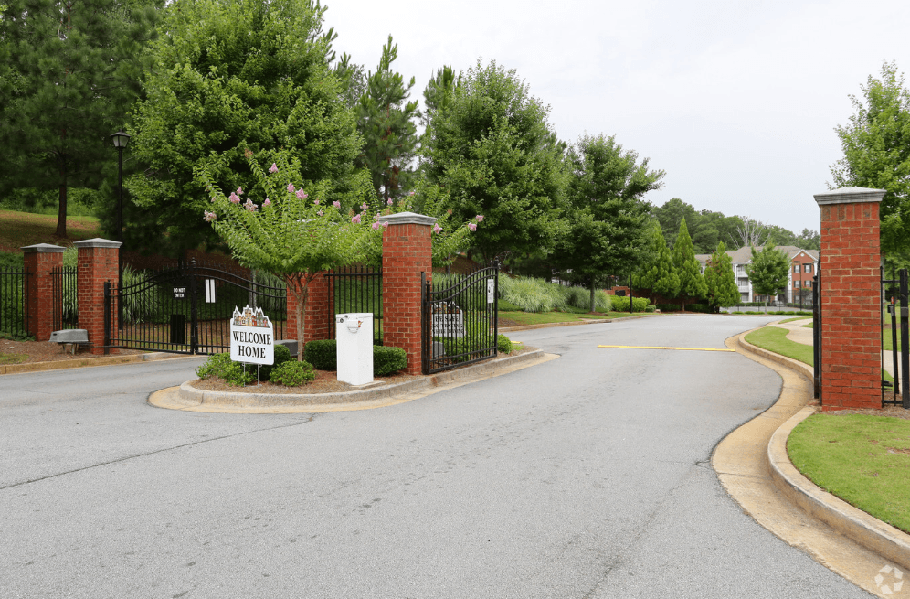 the street in front of a house with a driveway and a gate