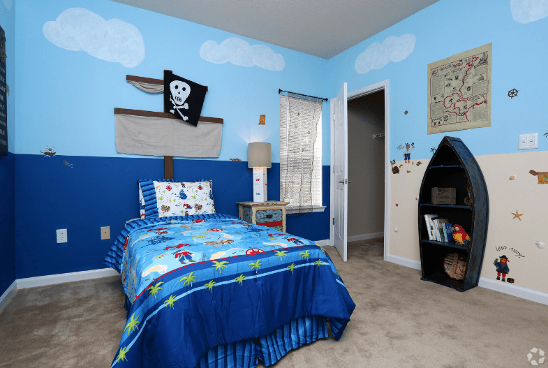 a bedroom with a bed and a surfboard in the corner