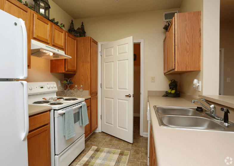 a kitchen with white appliances and wooden cabinets