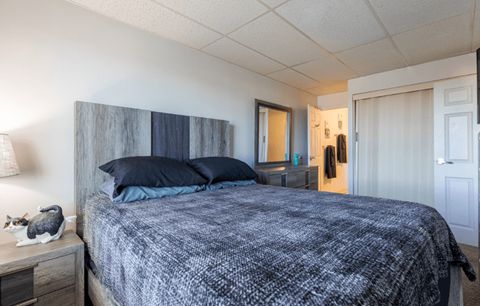 A bedroom with a bed, nightstand, and lamp.