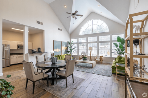 A modern open plan living and dining room with a kitchen in the background.