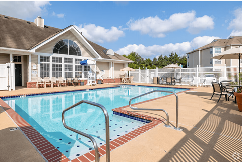A swimming pool in a residential area with a house in the background.