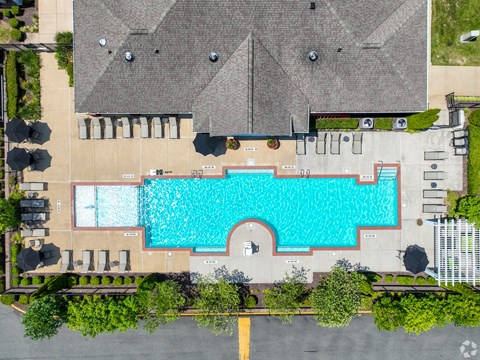 An aerial view of a swimming pool surrounded by buildings and trees.