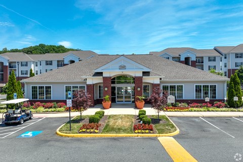 A golf cart is parked in front of a building with a parking lot in front of it.