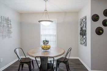 A dining room with a round table and chairs.