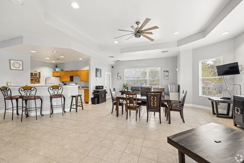 A spacious kitchen and dining area with a ceiling fan and a television.