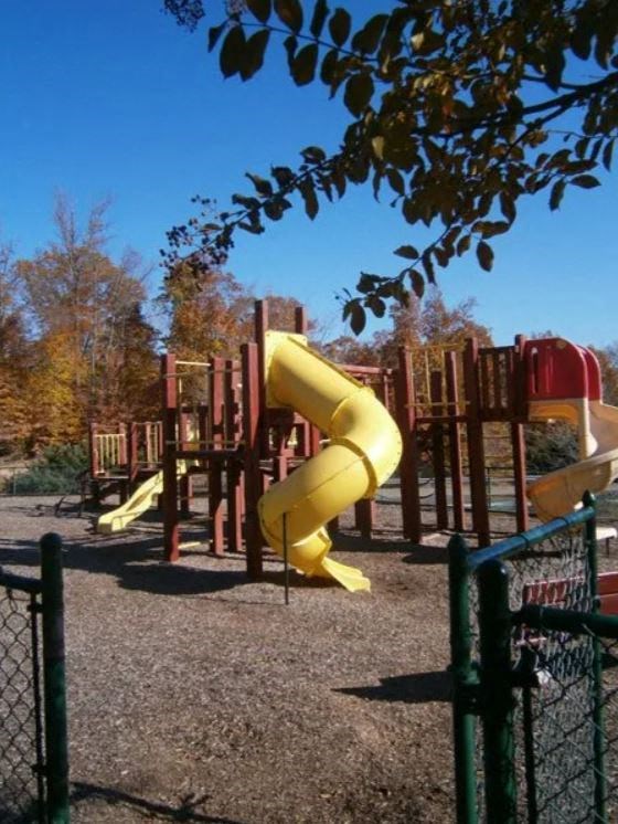 A playground with a yellow slide and a red slide.at The Village at England Run, Fredericksburg, Virginia  