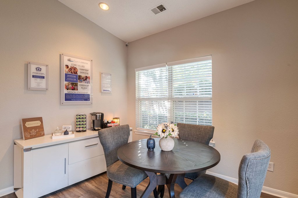 A dining room with a table set for two and a window with blinds.at The Village at England Run, Fredericksburg, VA 22406  