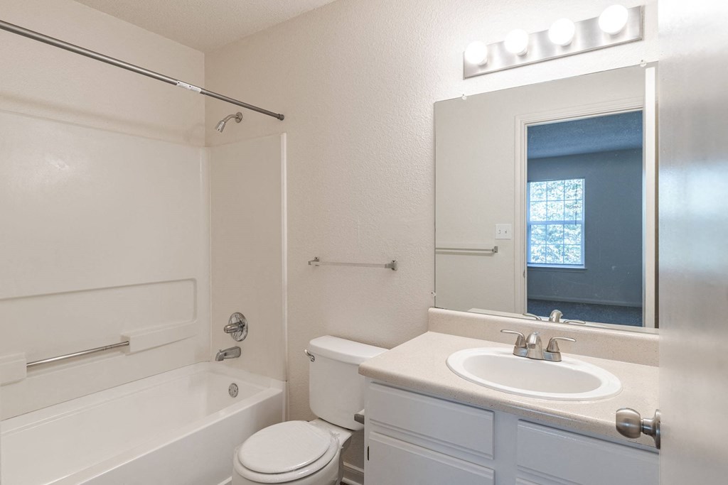 A white bathroom with a toilet, sink, and bathtub.at The Village at England Run, Virginia, 22406