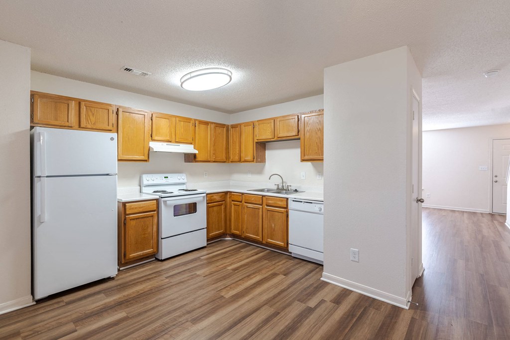 A kitchen with wooden cabinets and white appliances.at The Village at England Run, Fredericksburg, VA  