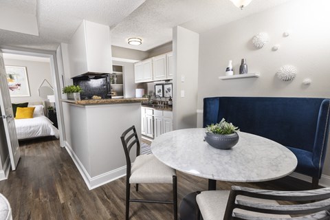 a dining room with a table and chairs and a kitchen with a sink