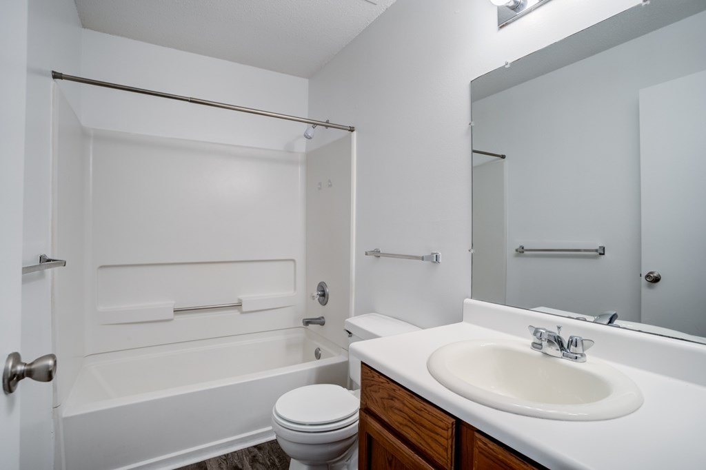 A white bathroom with a toilet, sink, and bathtub.