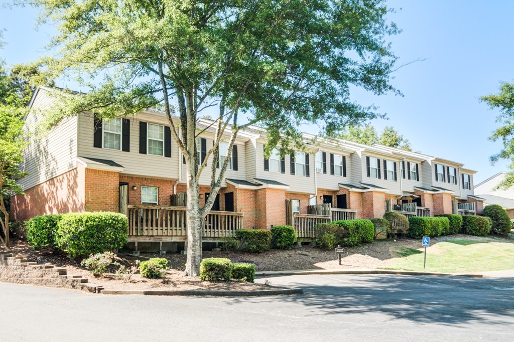 A row of houses with a tree in front of the first one.