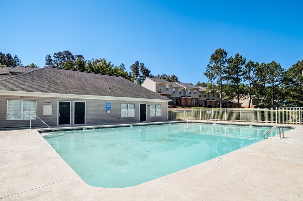 A swimming pool in front of a building with a blue sign.