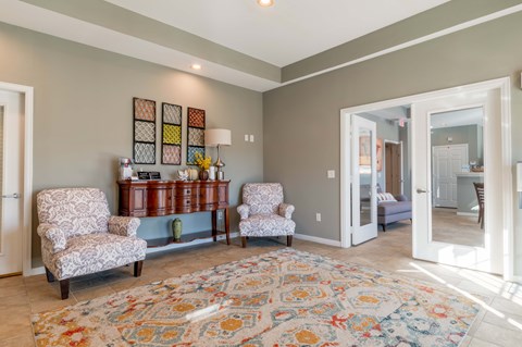 A living room with a rug and two chairs.