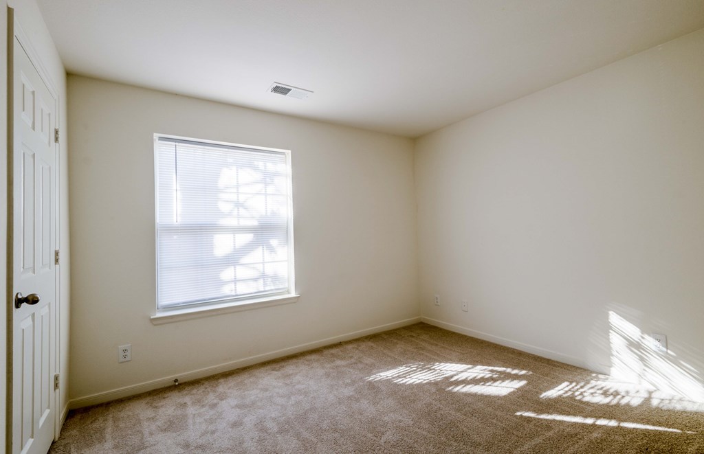 A room with a window and sunlight coming through.