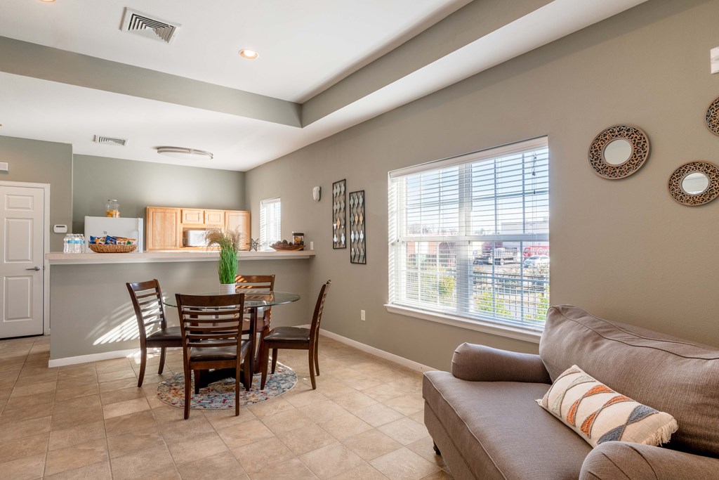 A well-lit living room with a dining table and chairs.