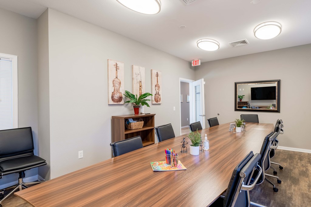 A conference room with a long table and chairs.