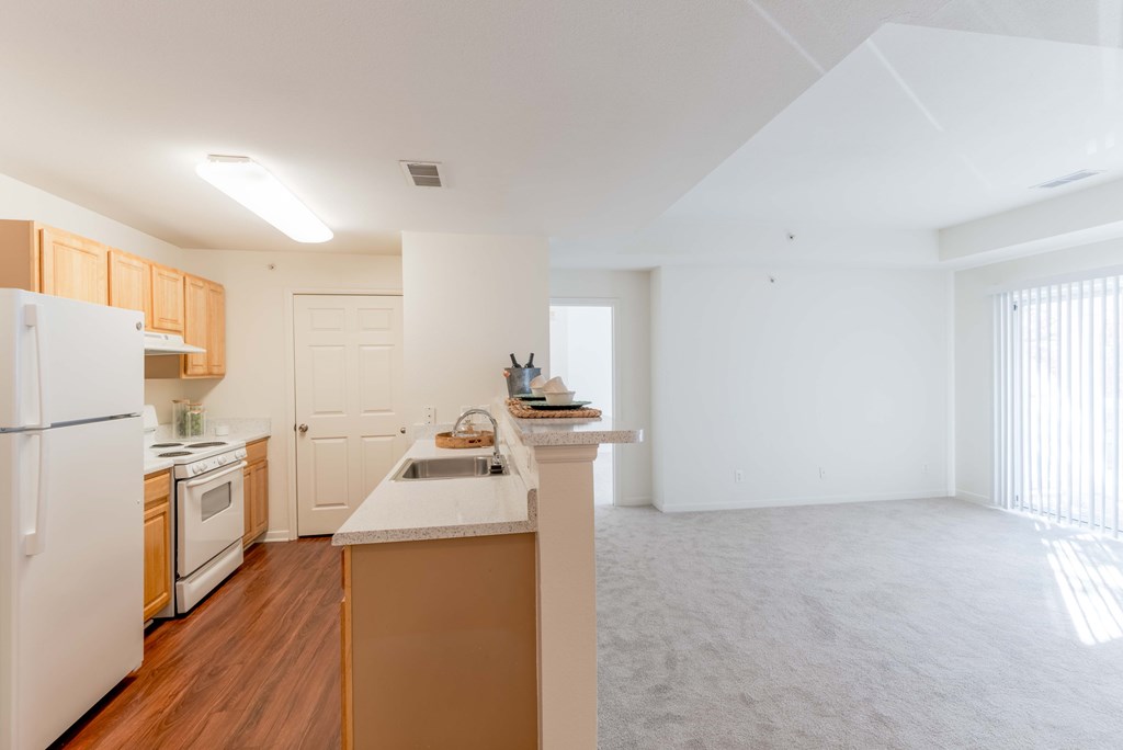 A kitchen with white appliances and wooden cabinets.
