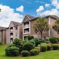 Apartment building with a green lawn in front.