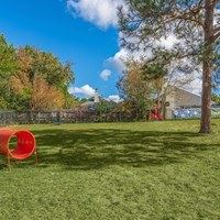 A red tunnel is in the middle of a grassy field.