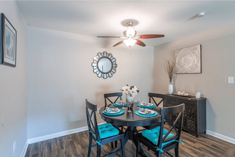 a dining room with a table and chairs and a ceiling fan at Bradley Square, North Charleston  