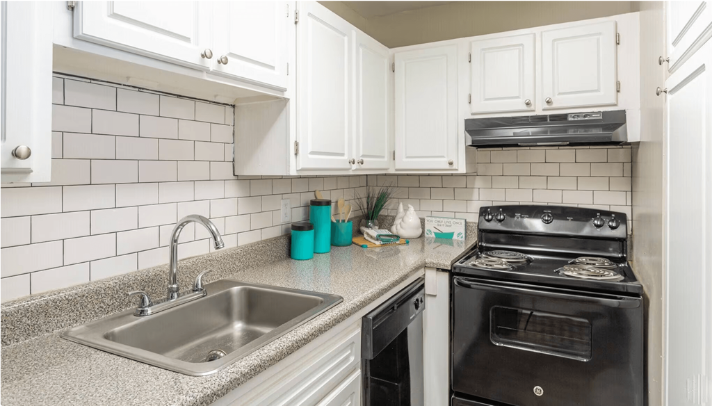 a kitchen with white cabinets and black appliances at Bradley Square, South Carolina   