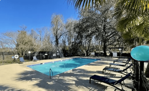 a swimming pool with benches and trees in the background at Bradley Square, North Charleston, SC 29406