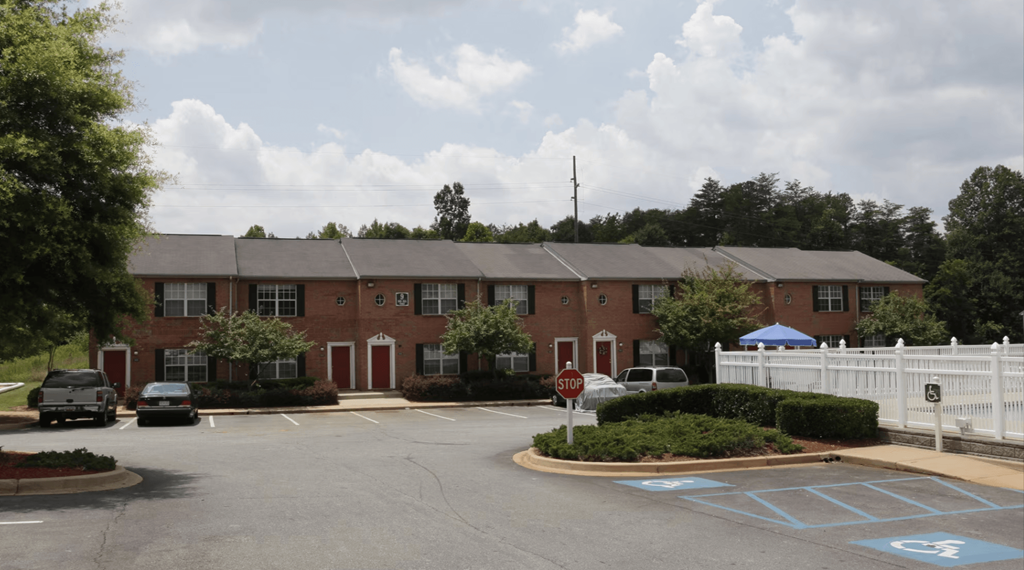 an apartment building with a parking lot in front of it