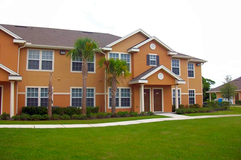 an orange house with palm trees in front of it